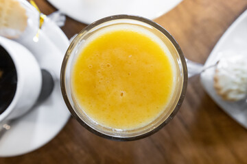 elevated perspective of table with crystal glass with natural orange juice, organic and refreshing fruit, restaurant table, menu