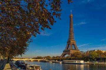 Eiffel Tower Enlightened by Sun at Day in Paris Fall Colors Trees Seine River and Boat Cruises