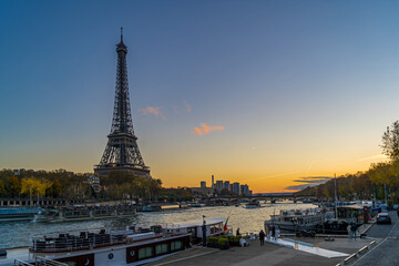 Fototapeta na wymiar Blue Hour in Paris With Tourists Cruises on the Seine River and Eiffel Tower