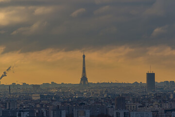 Fototapeta premium Eiffel Tower in a Stormy Morning With Denses Clouds Moving Fast Lights and Shadows Paris