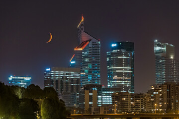 Orange Crescent Moon Over Towers of La Defense Business District at Night