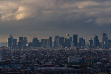 Fototapeta na wymiar La Defense Business District Under Stormy Clouds With Sunlight on Towers Paris