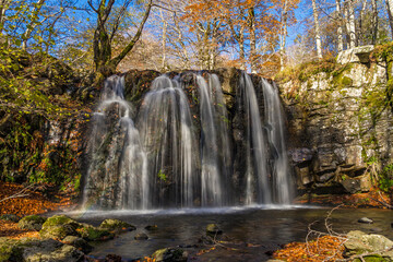 Fototapeta na wymiar Waterfall in a Beautiful Place With Fall Color Rocky Ground Lights and Shadows