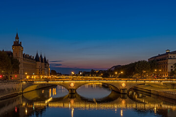Fototapeta na wymiar Enlightened Bridge Over Seine River at Blue Hour in Paris Center With Reflections
