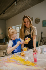 Mom and daughter mixing paints draw a picture vertical photo