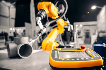 Closeup yellow arm robot welding metal pipe part in industry factory