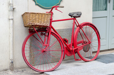 Fototapeta na wymiar red bicycle. historic bicycle with basket leaning against a wall.