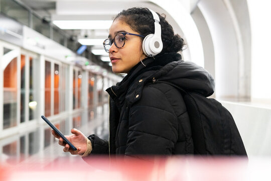 Ethnic woman using smartphone on underground station