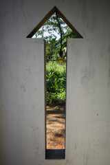 Unawatuna, Sri Lanka An arrow-shaped window in a wall looks into a garden.