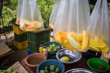 Udawalawa, Sri Lanka A farm stand by the side of the road sells fresh fruit like mangoes and pineapple in plastic bags.
