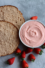 Strawberry cream, cake layers and juicy strawberries on a table. Close up photo of homemade cake in process. Layer cake ingredients top view. 