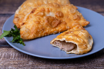 Chebureks with meat. Deep-fried flat pie. A traditional dish. Close-up.