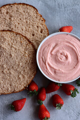 Strawberry cream, cake layers and juicy strawberries on a table. Close up photo of homemade cake in process. Layer cake ingredients top view. 