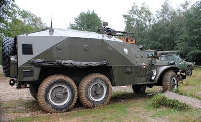 An historic military transport vehicle standing in the forest