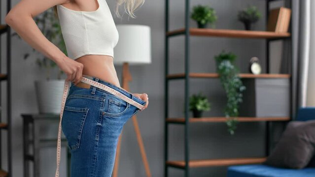 Closeup female body measurement big jeans size checking diet weight loss results healthy lifestyle