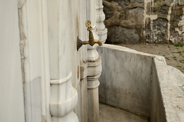 Old faucet on a stone outdoors

