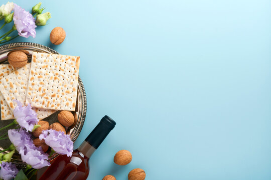Pesach Jewish holiday. Passover celebration concept. Matzah, red kosher wine and walnut. Traditional ritual Jewish bread on light blue background. Passover food.