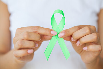 Doctor in uniform holds a green ribbon as a symbol of Lyme disease