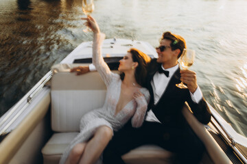 Stylish young bride and groom huging and kissing on yacht