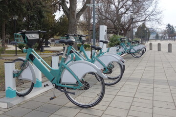 public rent bicycles. stands in row on rental network parking lot waiting ready for cyclists 