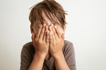 boy covering his face with hands