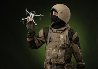 a soldier in military clothes with a weapon launches a small unmanned quadcopter for reconnaissance...