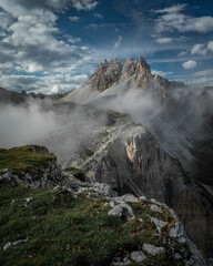 Mountain Paternkofel with fog in Three Peaks Nature Reserve in the Dolomite Alps in South Tyrol with clouds in blue sky.