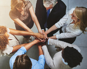 Get involved, get it done. High angle shot of a group of colleagues joining their hands in solidarity.