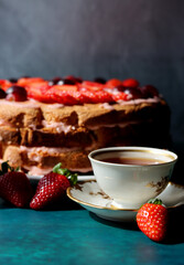 Still life with cake and cup of black tea. Strawberry layer cake close up photo. Beautiful retro styled tableware on a table. Birthday celebration photo.  