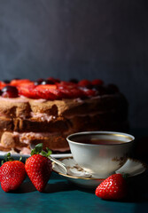 Still life with cake and cup of black tea. Strawberry layer cake close up photo. Beautiful retro...