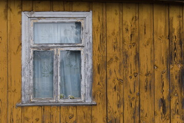 Rustic window in wooden village cottage house. Yellow wood wall