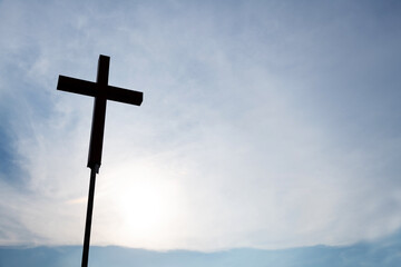 A christian cross under cloudy sky