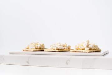 Tostadas de queso de cabra sobre mármol. Aperitivo sobre fondo claro	