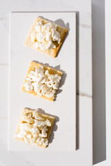 Tostadas de queso de cabra sobre mármol. Aperitivo sobre fondo claro. Vista superior	