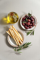 Kalamata olive, Aceitunas Kalamon and grissini breadsticks, olive oil. mediterranean snacks on the white modern style, top view