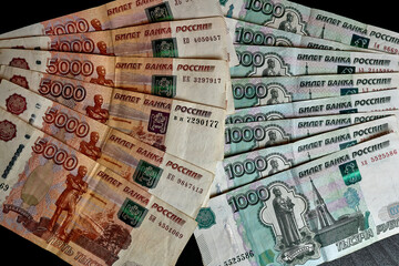 A scattering of five thousandth and one thousandth banknotes of Russian rubles