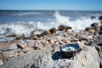 Fototapeta na wymiar Old brass compass on the sea shore background. Sea travel.