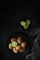 Fresh and ripe kiwis on a dark background. Healthy food photography. Fruit rich in vitamin C