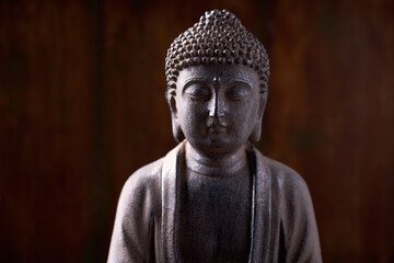 Meditating Buddha Statue on dark wooden background. Close up. Copy space.	