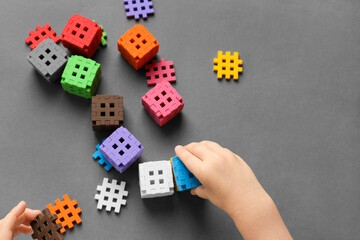 Child is playing with multi-colored blocks