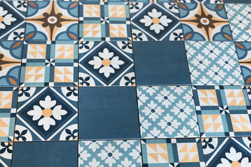 Blue and white tiles with flowers and yellow shapes and patterns.