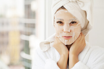 Beautiful Woman Applying Paper Sheet Mask On Her Face White