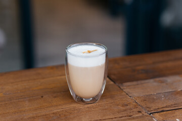 Cappuccino on the table. Delicious cappuccino in a glass mug.