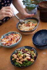 mixed salats on a kitchen counter with a person steering