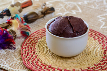 Acai. Bowl of Brazilian açai on a table with handicrafts from the Amazon region blurred in the background.