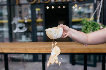 Woman holding latte art coffee on wooden table in coffee shop. Coffee in a mug.