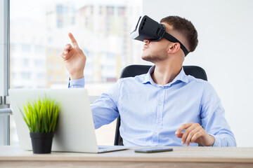 Man in office clothes and virtual reality glasses touching air.