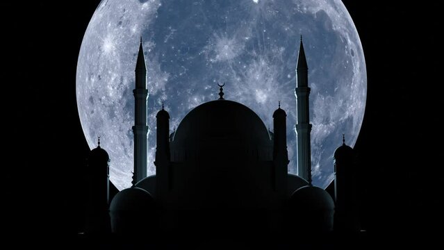 
A large moon rises over the mosque during Ramadan. 