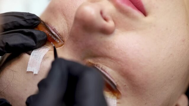 lamination of cilia on the eyes the master straightens the laminated eyelashes on the silicone patch and tramples them