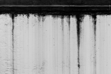 Black dirty spots of fuel oil flow liquid down spill the white old wall surface chemical industry...